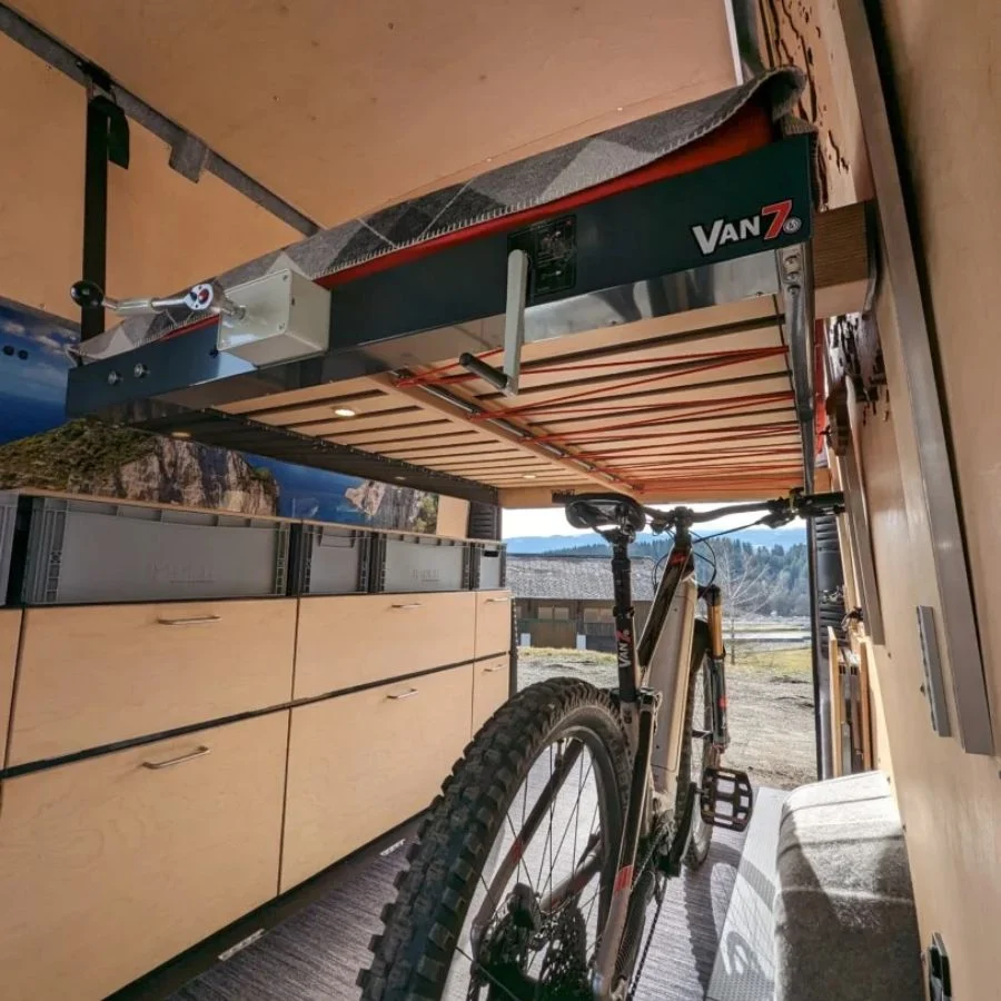 E-bike stored under the VAN7 lift bed with mountains outside
